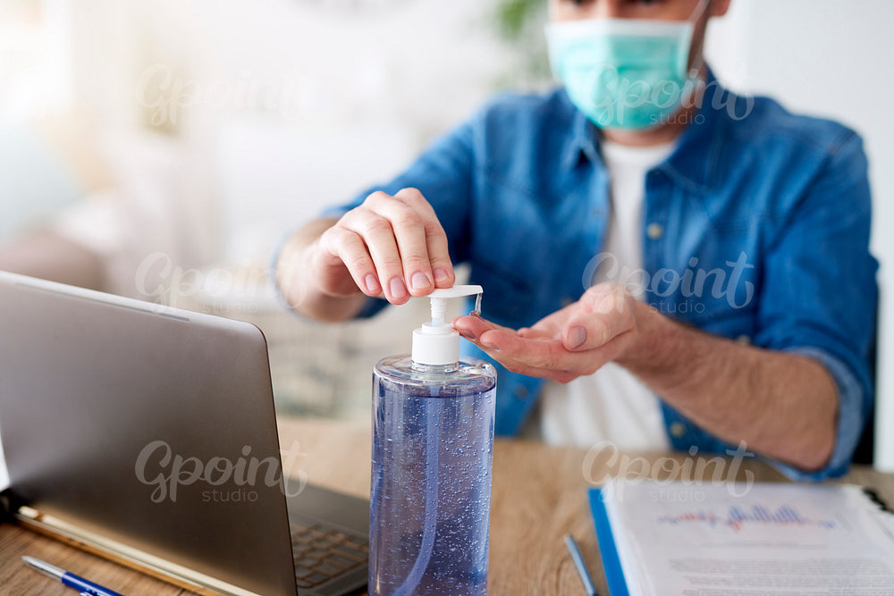 Man cleaning hands before work on computer