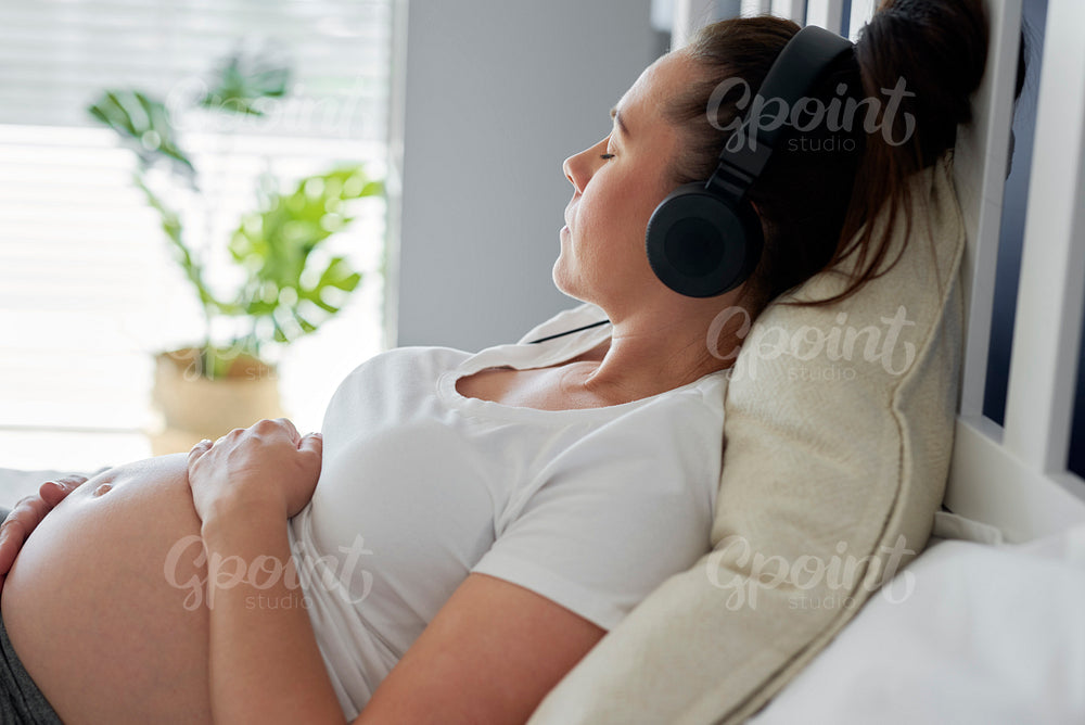 Pregnant woman relaxing while listening to music