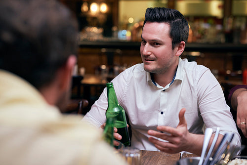 Handsome men drinking beer in the pub
