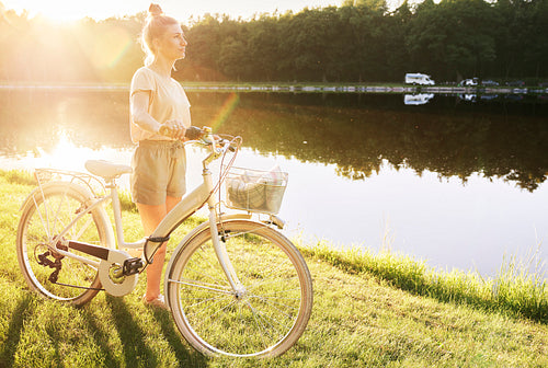 Woman with bike by the lake