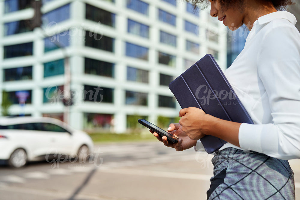 Close up of businesswoman with digital tablet and phone outdoors