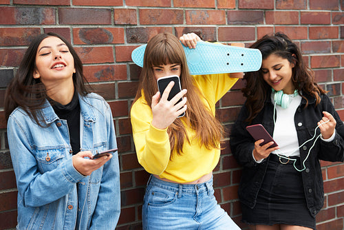 Three young women having fun with mobile phone