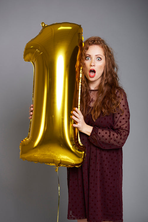 Screaming woman holding golden balloon