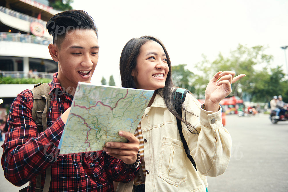 Asian couple using paper map on the street