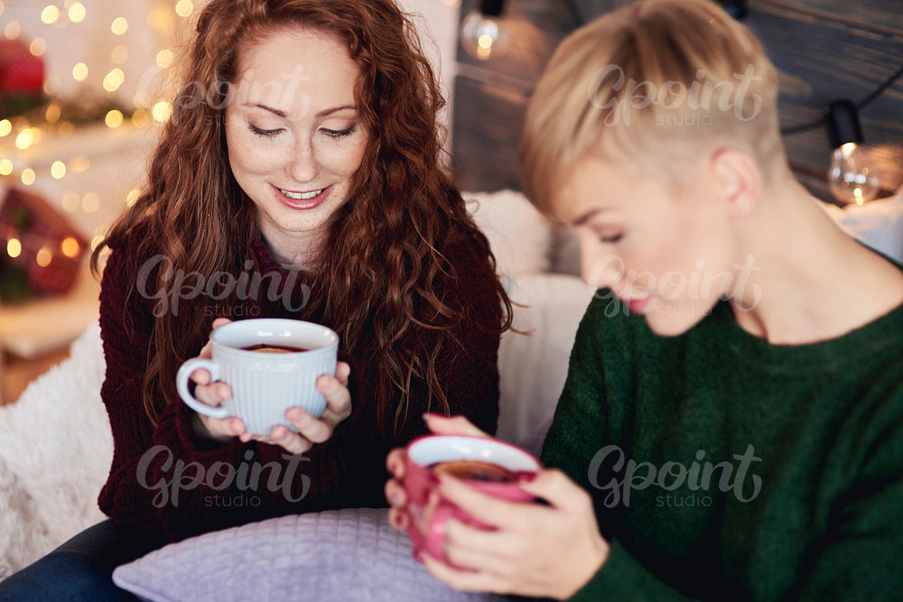 Beautiful girls drinking hot tea with lemon in winter day