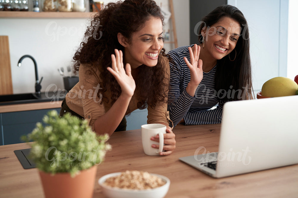 Happy women waving during a video conference