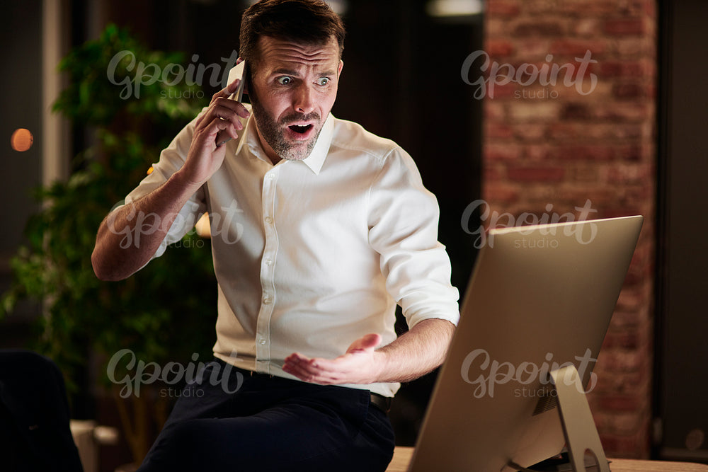 Worried businessman talking by mobile phone