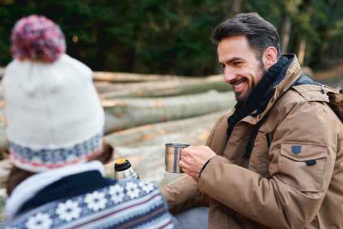 Happy men drinking tea in the autumn forest