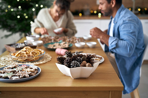 Christmas decorations at the table with couple in background at home