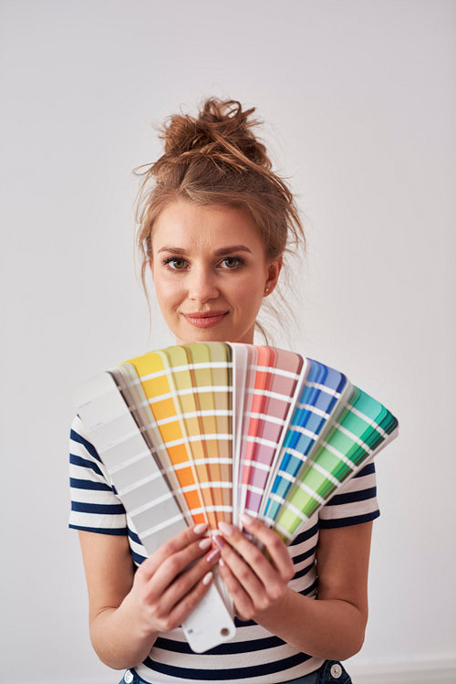 Portrait of smiling woman showing color swatch