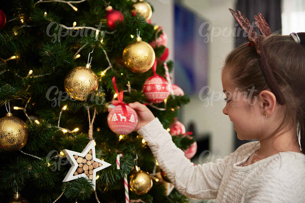 Child decorating the Christmas tree