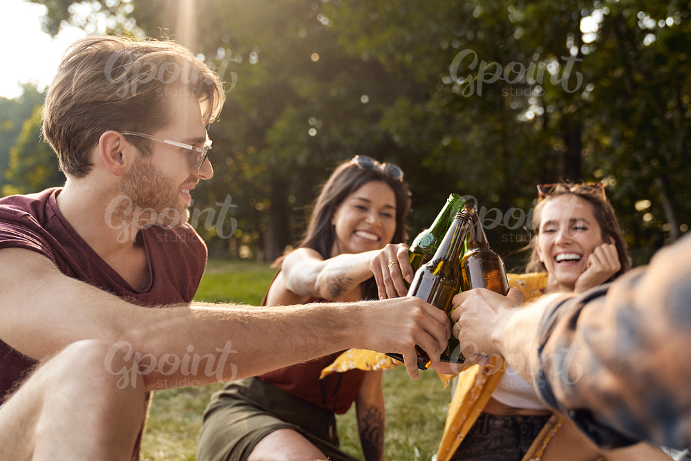 Group of young friends spending time on the camper side on drinking beer 