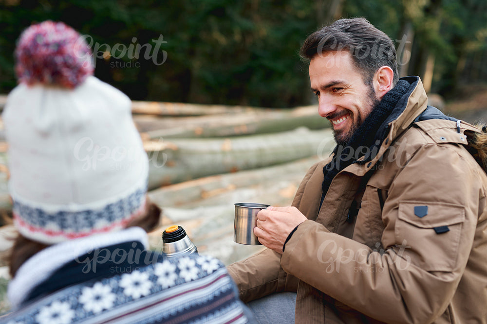 Happy men drinking tea in the autumn forest