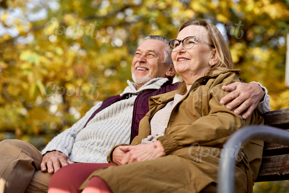 Senior caucasian couple sitting at the bench in park   