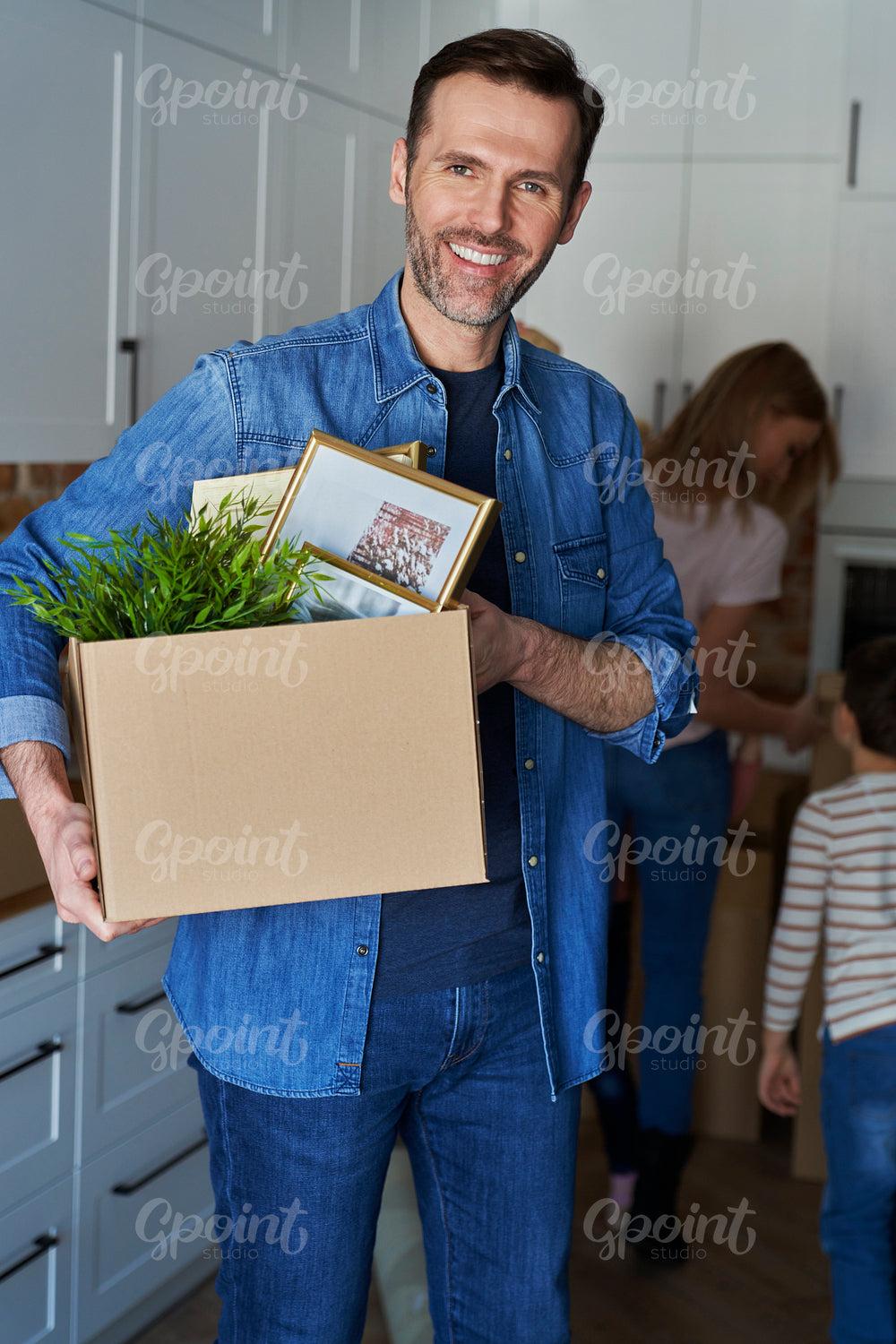 Portrait of smiling man holding cardboard box during moving