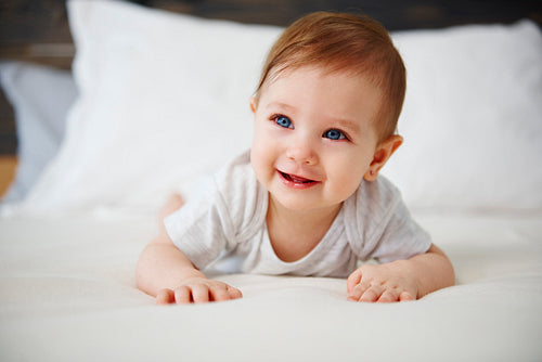 Charming baby lying on the bed