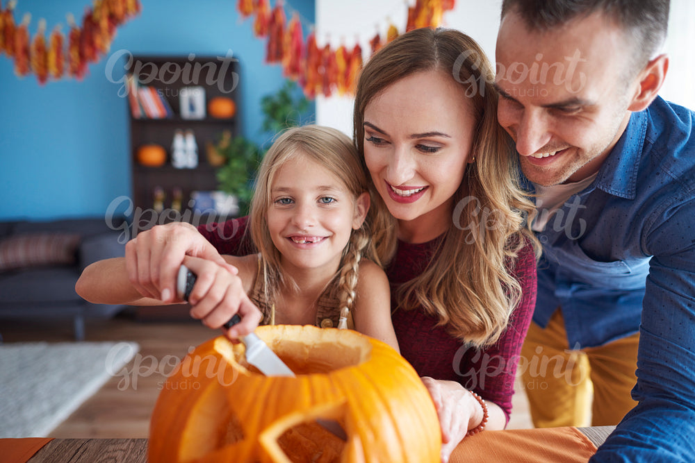 Whole family drilling halloween pumpkin