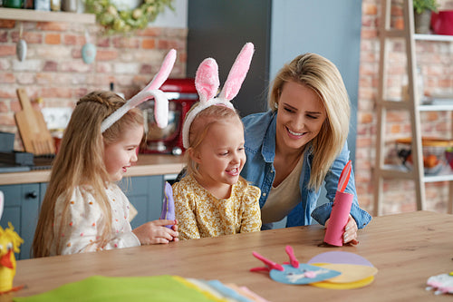 Mother and two little daughters playing with handmade Easter toys