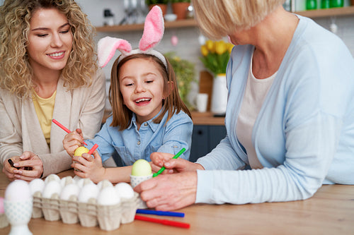 Happy family decorates easter eggs at home