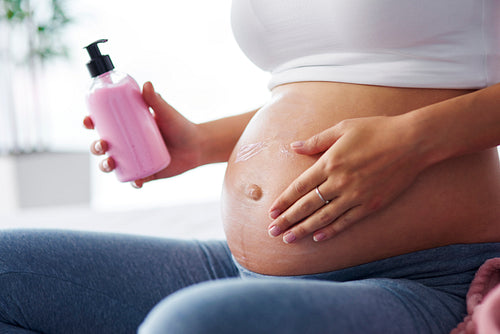 Pregnant women applying cream