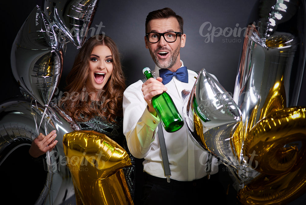 Friends with champagne bottle and balloons