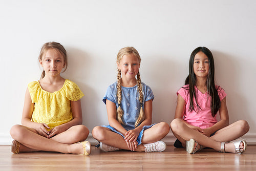 Three girls sitting with crossed legs