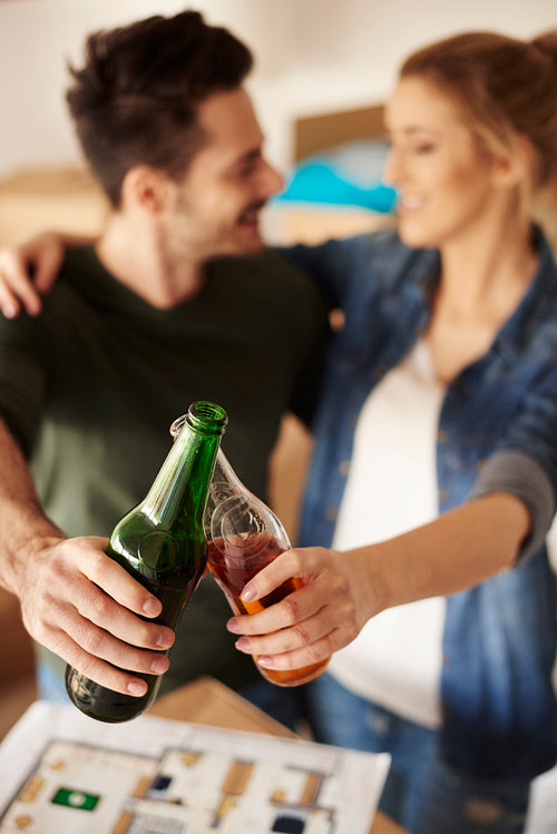 Young couple toasting beer bottles