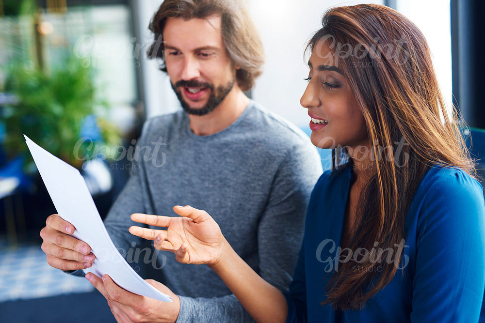 Young adults coworkers analyzing document