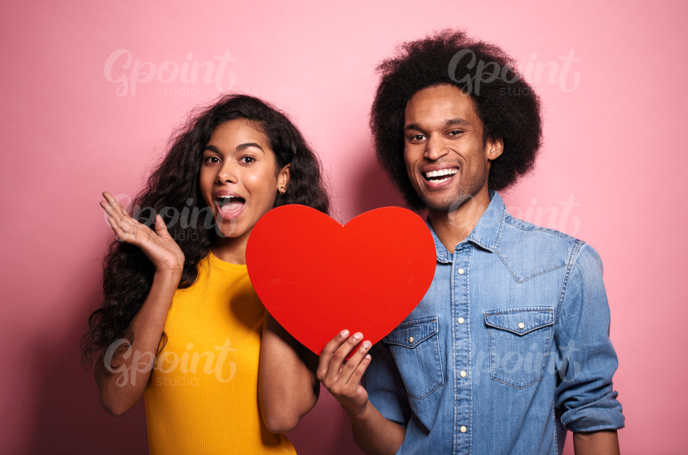 Happiness  African couple holding a red heart in studio shot.