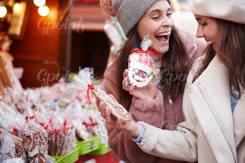 Two women buying ginger breads on Christmas market