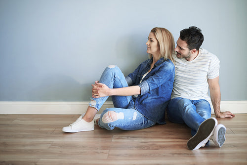 Young couple sitting on the floor of new house