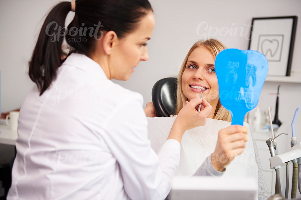 Stomatologist checking the woman's teeth during dental checkup