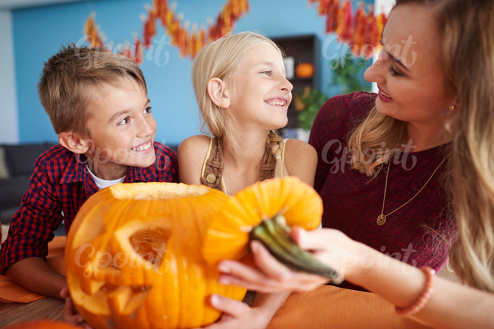 Family drilling big halloween pumpkin
