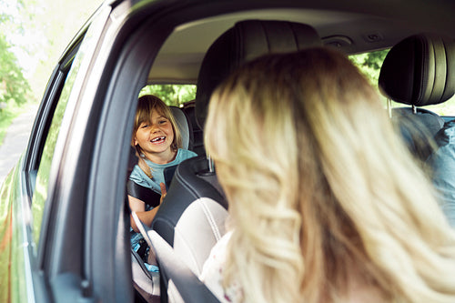 Little girl smiling do her mother in the car