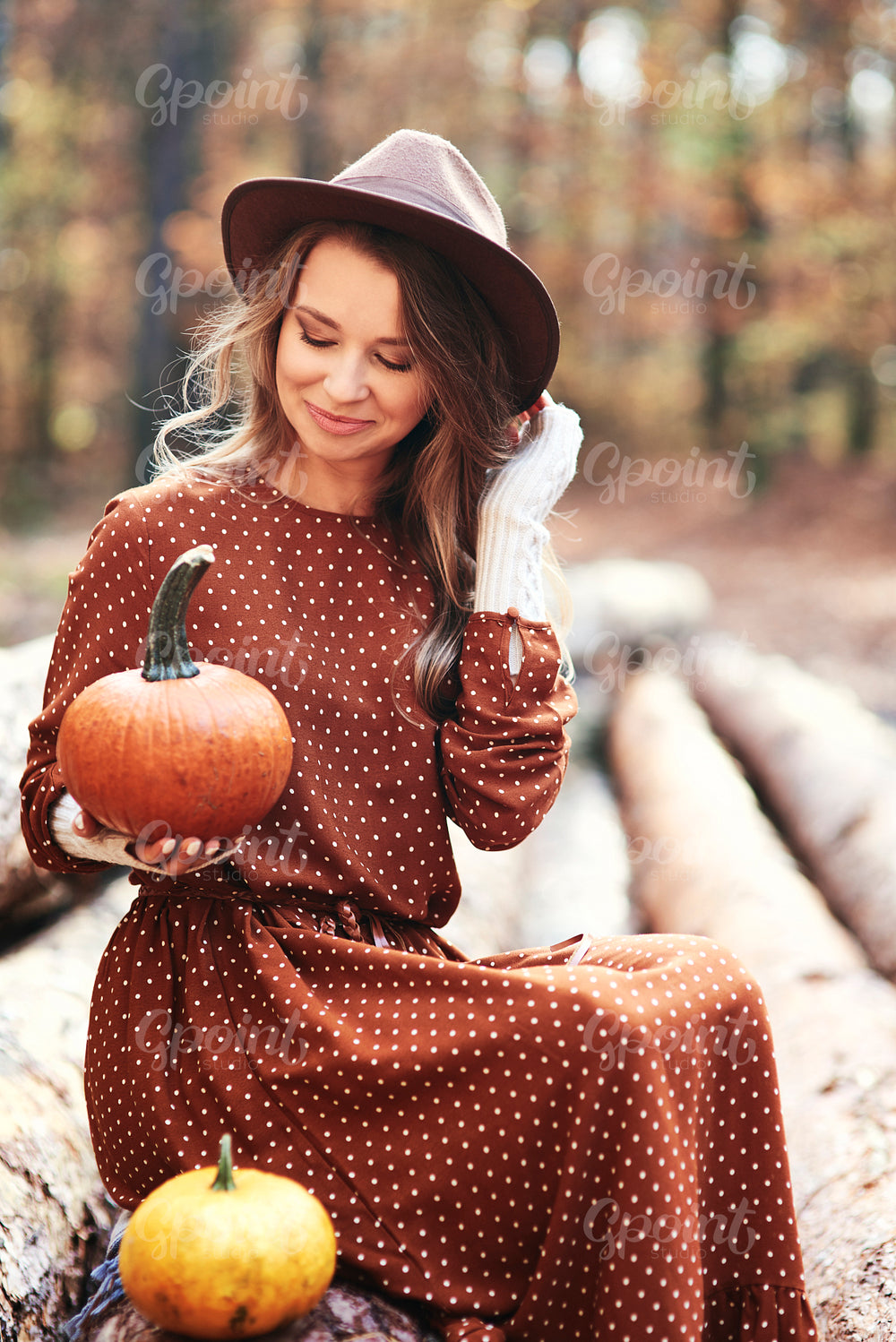 Woman sitting and holding some pumpkins