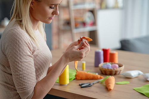 Close up of woman sewing Easter decorations