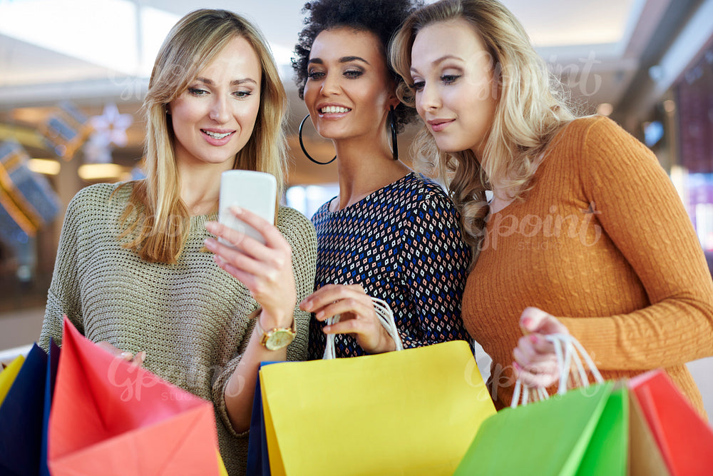 Girl using her mobile phone during the shopping