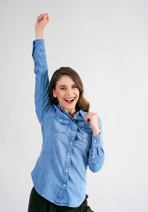 Successful young woman with hand raised