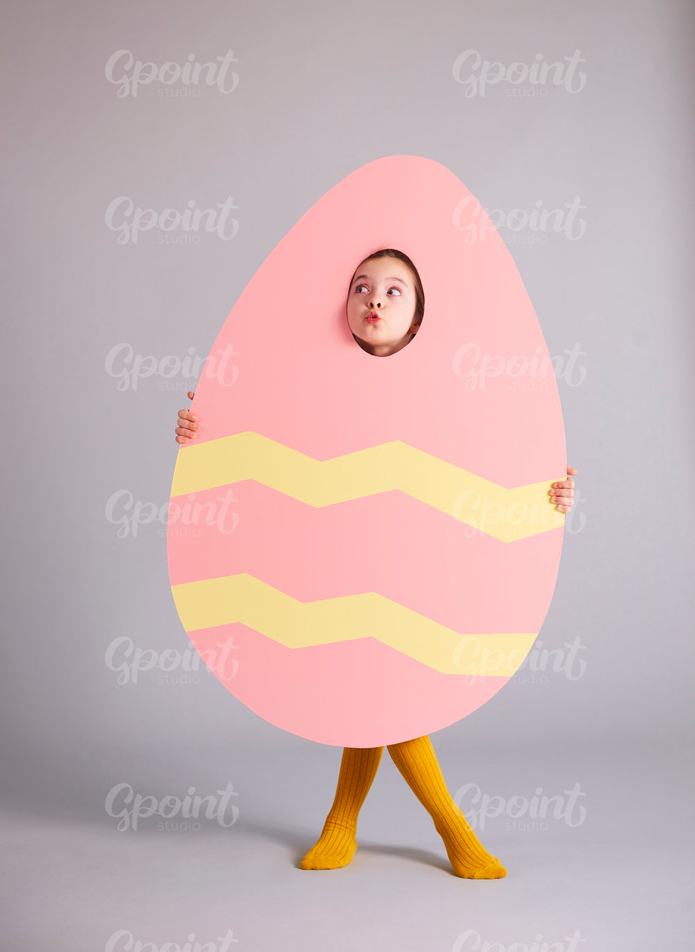 Playful girl holding easter banner and looking at copy space