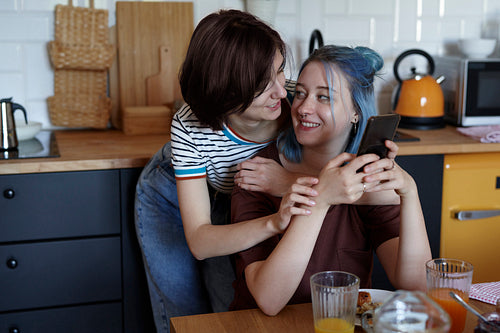 Happy lesbian couple hugging during breakfast