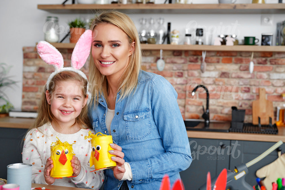 Portrait of smiling mother and daughter with handmade Easter chickens