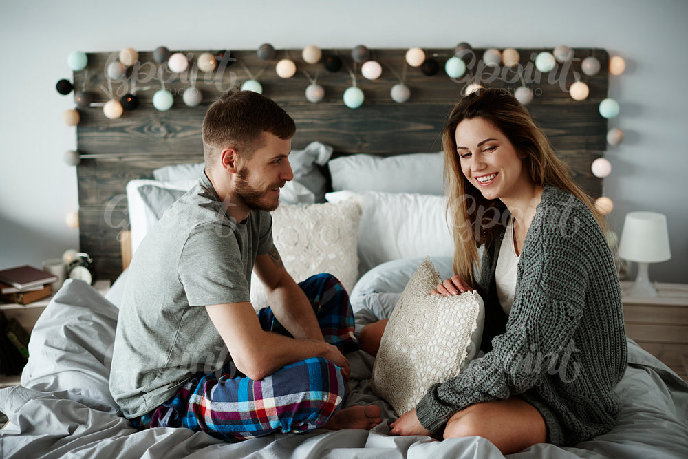 Cheerful couple talking in bed