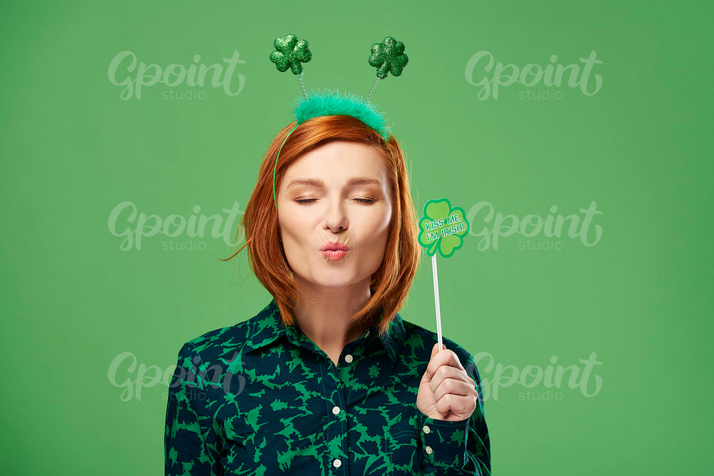 Playful woman with closed eyes blowing a kiss