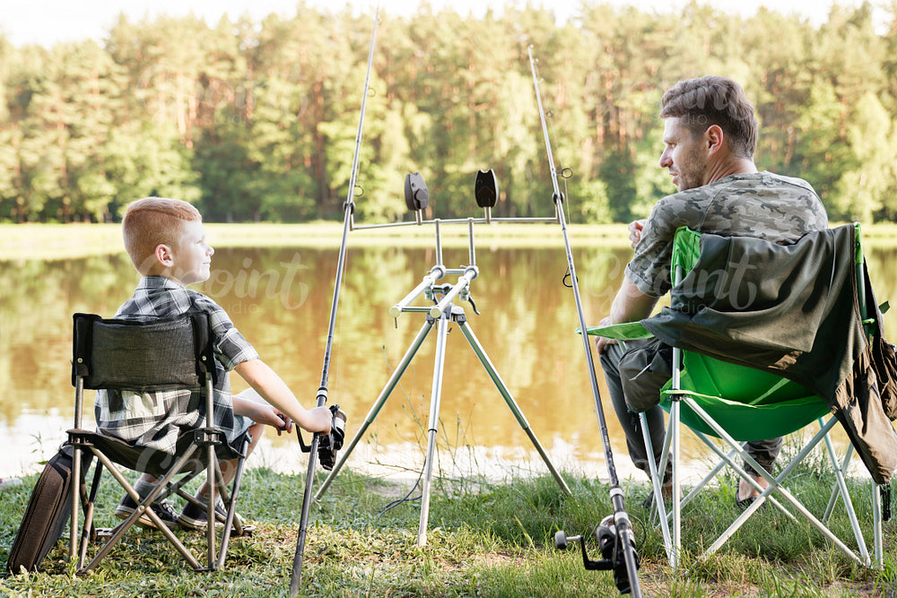 Rear view of father and little son on fishing