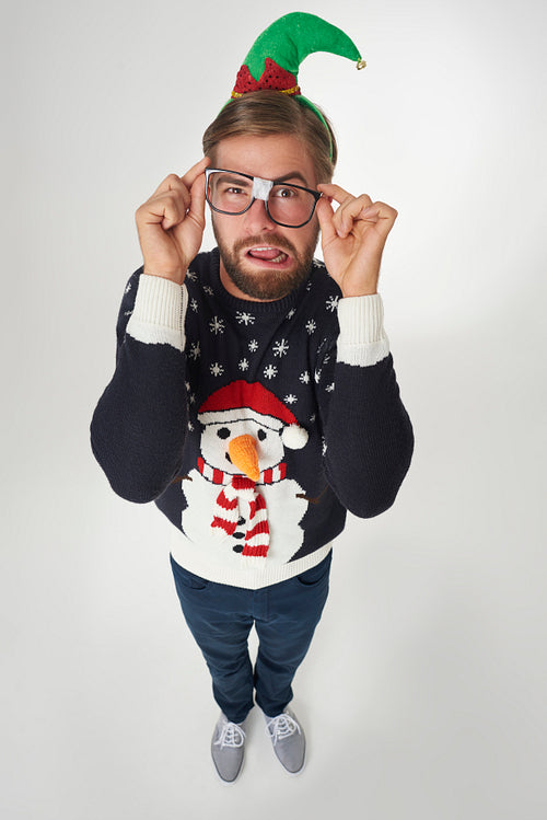 Man in Christmas clothes and broken glasses