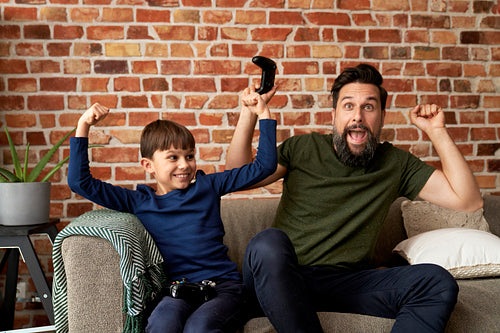 Father and son have fun while playing video game