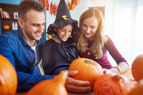 Parents with son choosing perfect pumpkin