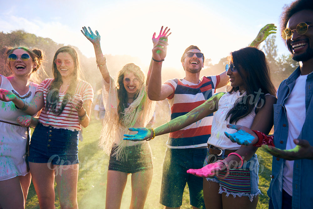 Friends having fun during music festival with colour powders
