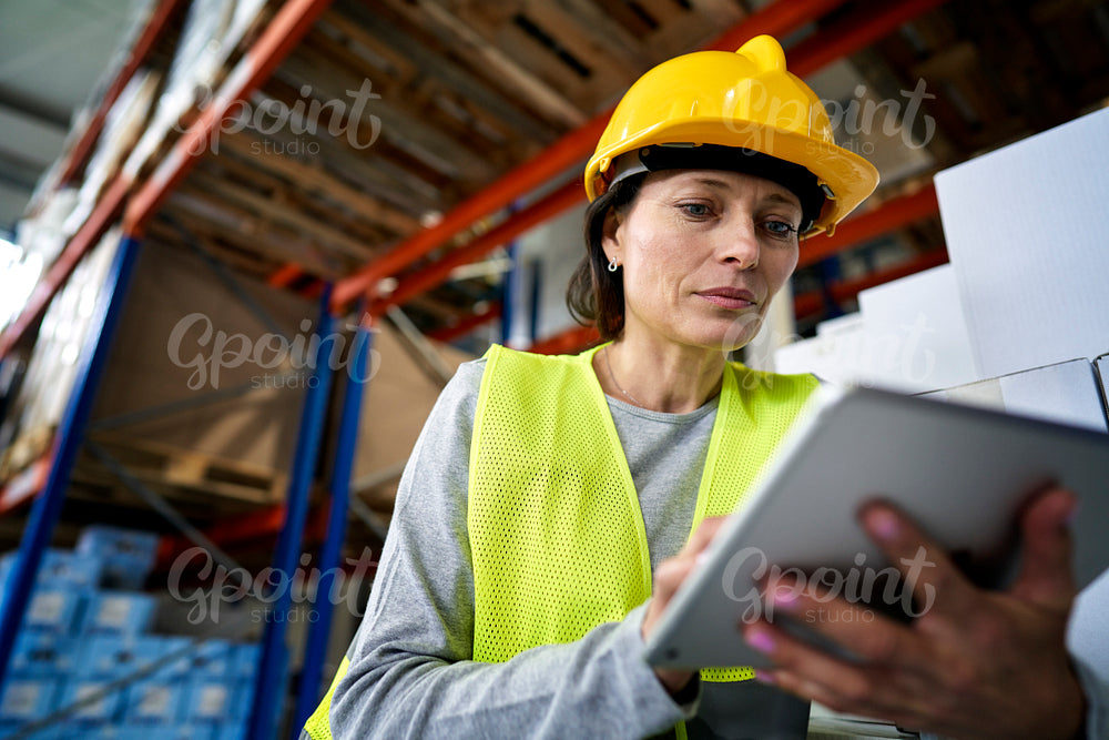 Caucasian warehouse female worker working using digital tablet