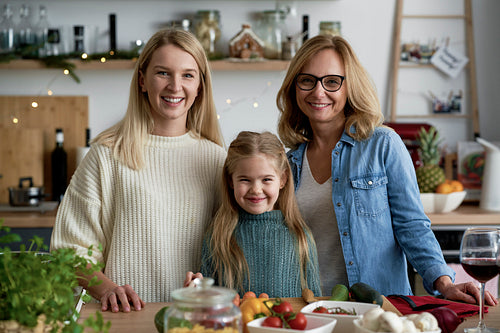 Portrait of three generations of women in kitchen during Christmas time
